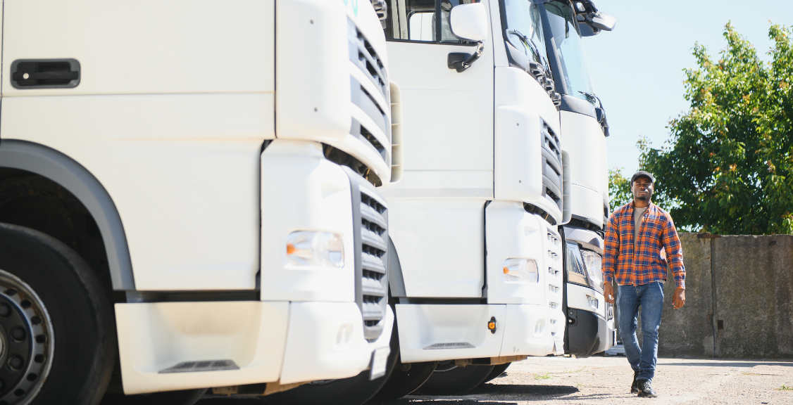 a man walking towards a line of trucks